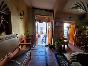 a hallway of a house with a person walking out the door at Hotel Villarreal in Zacatecas