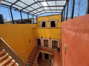une vue sur un bâtiment jaune avec un plafond en verre dans l'établissement Hotel Villarreal, à Zacatecas