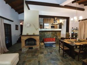 a living room with a fireplace and a dining room at VILLA GEORGIA in Acharavi