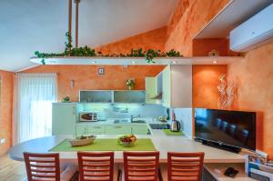 a kitchen with a table and some orange walls at Apartman Maksim in Banjole +12 photos