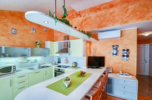 an orange kitchen with a large white counter top at Apartman Maksim in Banjole