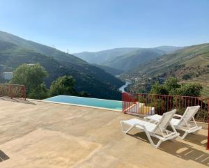 a pair of chairs on a patio overlooking a valley at Terraços do Távora in Tabuaço