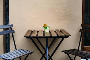 Una pequeña mesa con una flor en un jarrón. en Casa Mole en Turín