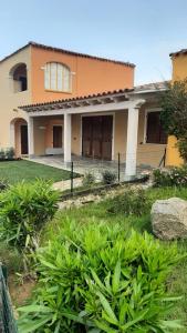 a house with a yard with plants in front of it at Appartamento Residence Mirice Vignola mare Aglientu casa Giorgia in Aglientu