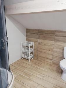 PAKLADA 3 Pokój typu studio في Karsin: حمام مع مرحاض وأرضية خشبية