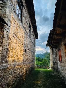 an alley in an old stone building with mountains in the background at Cottage Modrich in Struga