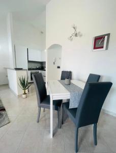 una sala da pranzo con tavolo e sedie bianchi di Apartment Civico35 a Olbia