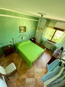 ベルヴェデーレ・マリッティモにあるB&B La Torreのベッドルーム(緑のベッド1台、窓付)