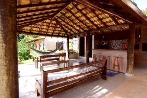 um pavilhão com bancos e uma rede de descanso num pátio em Suítes Alto Itamambuca em Ubatuba