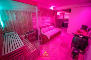 Habitación rosa con sofá y mesa en L'EXCELLENCE AVIGNON - Suite LUXE SAUNA, HAMMAM & JACCUZZI en Aviñón