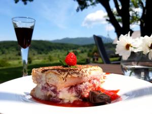 un trozo de pastel en un plato con una copa de vino en Tesla's Gastro House Plitvice en Lagos de Plitvice