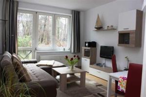 ein Wohnzimmer mit Couch und Fernseher in der Unterkunft Zinnowitz Haus Zur Düne in Zinnowitz