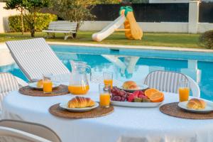 a table with plates of fruit and juice next to a pool at Villa in Esposende in Esposende