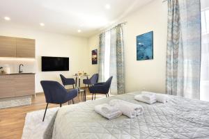 a bedroom with a bed and chairs and a kitchen at D&A Central Luxury Apartments with FREE Parking in Pula