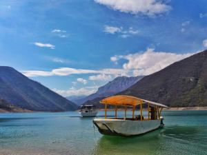two boats on a lake with mountains in the background at Guesthouse Madzarevic in Pluzine