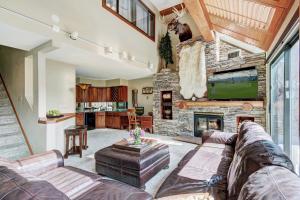 a living room with a couch and a stone fireplace at Beaver Run Black Diamond Penthouse Apartment in Breckenridge