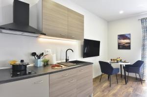 a kitchen with a sink and a table with chairs at D&A Central Luxury Apartments with FREE Parking in Pula