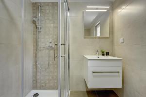a bathroom with a shower and a sink and a mirror at D&A Central Luxury Apartments with FREE Parking in Pula