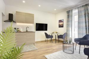 a living room with a kitchen and a table with chairs at D&A Central Luxury Apartments with FREE Parking in Pula