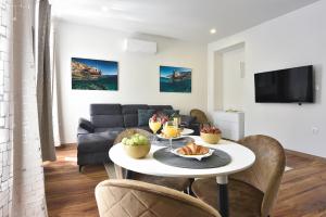 a living room with a table and a couch at D&A Central Luxury Apartments with FREE Parking in Pula