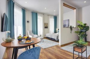 a living room with a table and blue curtains at D&A Central Luxury Apartments with FREE Parking in Pula
