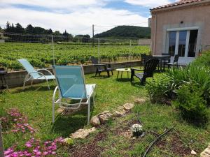 a group of chairs and tables in a yard at Moments de détente. in Carsan