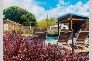 a group of chairs sitting next to a pool at Kâz corail in Sainte-Anne
