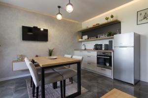 uma cozinha com uma mesa de madeira e um frigorífico em Deluxe Feliciano Apartments em Visoko