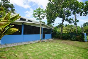 a blue house with a yard in front of it at Pavones Point Surf House in Great Location in Pavones
