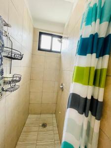 La salle de bains est pourvue d'une douche avec un rideau de douche coloré. dans l'établissement SuitesMB, à Playa del Carmen
