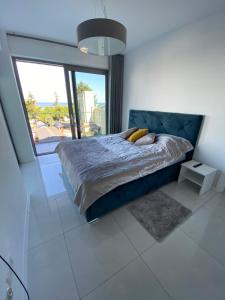 sypialnia z łóżkiem i dużym oknem w obiekcie MIĘDZYZDROJE,BALTICUS PROMENADA GWIAZD 14, Apartament z odrębnym salonem i sypialnią z Widokiem na morze w mieście Międzyzdroje