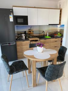 kuchnia ze stołem i krzesłami w kuchni w obiekcie MIĘDZYZDROJE,BALTICUS PROMENADA GWIAZD 14, Apartament z odrębnym salonem i sypialnią z Widokiem na morze w mieście Międzyzdroje
