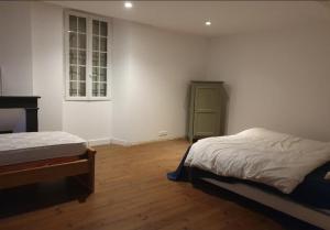 sypialnia z 2 łóżkami i zieloną szafką w obiekcie Maison Paisible au coeur des Pyrénées w mieście Igon