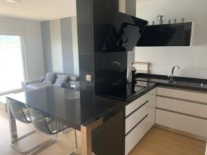 cocina con encimera negra en una habitación en Apartamento Praia de Quenxe, en Corcubión