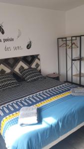 een slaapkamer met een bed met een blauw dekbed bij Chambre d'hôte la coccinelle in Meschers-sur-Gironde