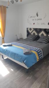 een bed met een blauw dekbed in een kamer bij Chambre d'hôte la coccinelle in Meschers-sur-Gironde