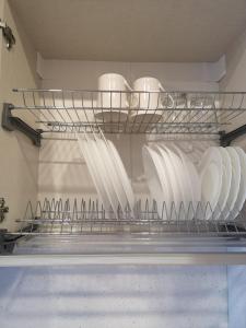 a shelf filled with white plates and utensils at Good Vibes :) in Juodkrantė