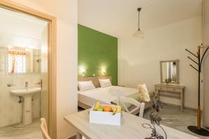 a room with a bed and a table with a bowl of fruit at Niriides Apartments in Stoupa