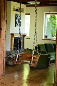 a swing in a living room with a fireplace at Pod Lipami in Zawady