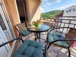 a patio with a table and chairs on a balcony at Apartman Lena in Vrnjačka Banja