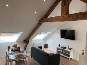 - un salon avec un canapé et une table dans l'établissement Nouveau ! Appartement loft hyper centre Bayeux, à Bayeux