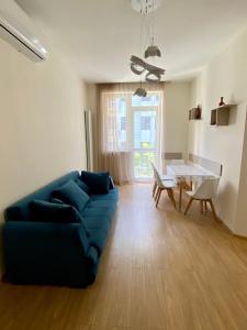 a living room with a blue couch and a table at Liberty Apartment in Tbilisi City