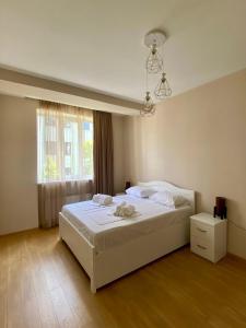 a bedroom with a white bed and a window at Liberty Apartment in Tbilisi City