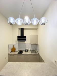 a kitchen with several lights hanging from the ceiling at Liberty Apartment in Tbilisi City