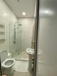 a white bathroom with a toilet and a shower at Liberty Apartment in Tbilisi City