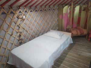 - une chambre avec un lit blanc dans une pièce avec des planches de surf dans l'établissement Ravissant yourte traditionnelle, à Quimper