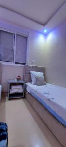 1 dormitorio con 1 cama y mesita de noche al lado en حدائق إفران, en Ifrane 12 fotos más