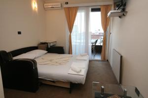 a small bedroom with a bed and a window at VilaElenaMarko in Budva +35 photos