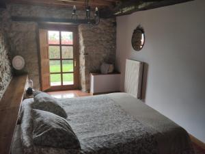 ein Schlafzimmer mit einem großen Bett in einem Zimmer mit einem Fenster in der Unterkunft El Mirador de Sorribes in Sevares