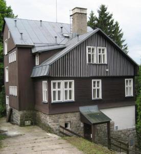 une grande maison avec un toit en gambrel dans l'établissement Hostel Pestalozza, à Špindlerův Mlýn
